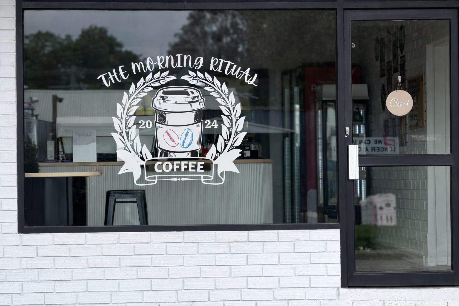 Cafe front window with The Morning Ritual logo decal and counter visible inside
