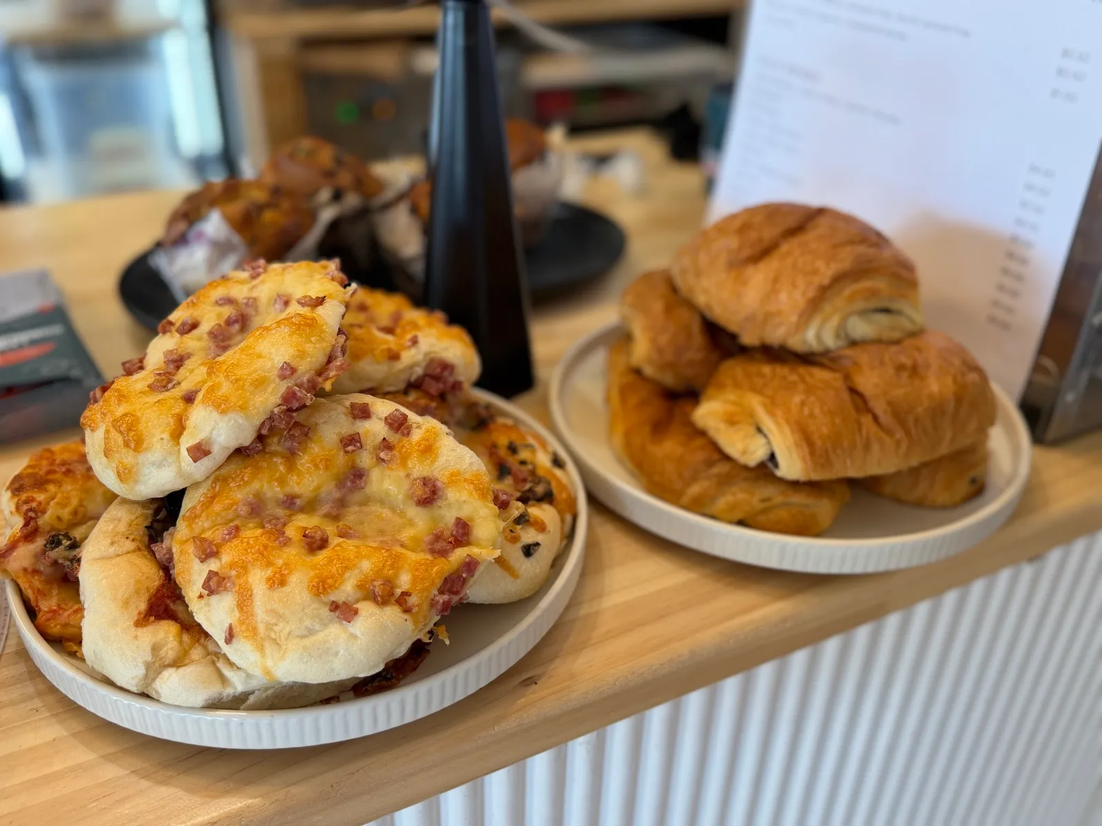 Plates of cheese-and-bacon scrolls and croissants on the cafe counter
