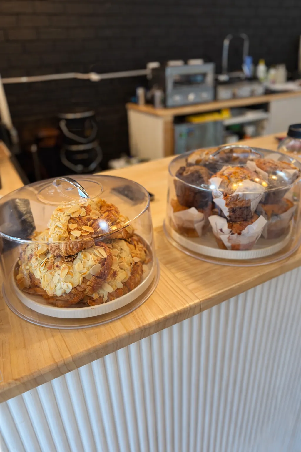 Glass cloche domes of croissants and muffins on the cafe counter